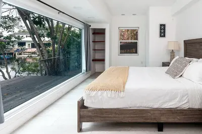 a bedroom with a bed and a large window at Aventura Lakefront in Miami