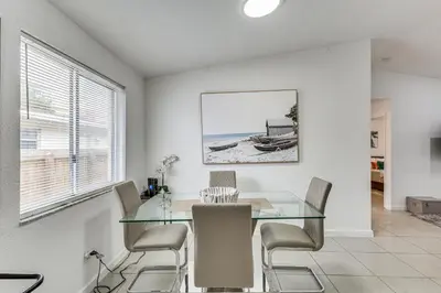 a dining room with a glass table and chairs at Walk to The Big Easy Casino Cozy Apt Near Beaches in Hallandale Beach