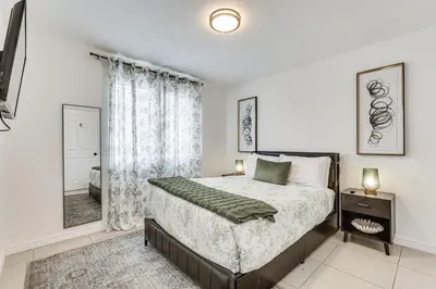 a bedroom with a bed and a large window at Walk to The Big Easy Casino Cozy Apt Near Beaches in Hallandale Beach