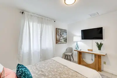 a bedroom with a bed and a desk and a tv at Walk to The Big Easy Casino Cozy Apt Near Beaches in Hallandale Beach