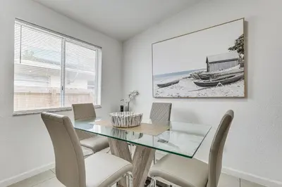 a dining room with a glass table and chairs at Walk to The Big Easy Casino Cozy Apt Near Beaches in Hallandale Beach