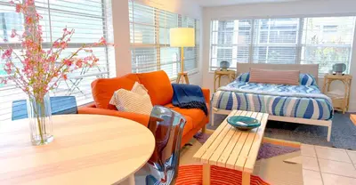 a living room with an orange couch and a table at Lazy Cabana- Pool Canal Wilton Drive in Fort Lauderdale