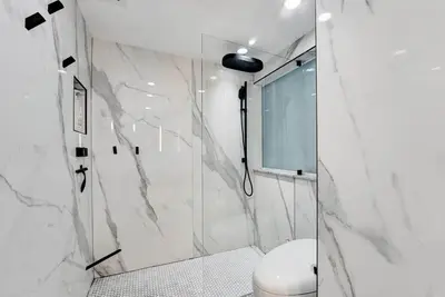 a white bathroom with a shower and a toilet at Versace Mansion Neighbor (Floors 2 & 3) Sleeps 12 in Miami Beach