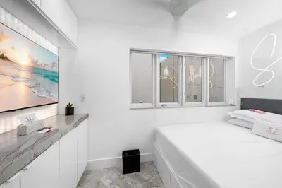 a white bedroom with a bed and two windows at Versace Mansion Neighbor (Floors 2 & 3) Sleeps 12 in Miami Beach