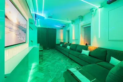 a living room with a couch and a large screen at Versace Mansion Neighbor (Floor 1) Sleeps 9 in Miami Beach