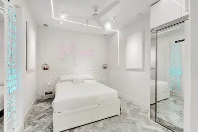 a white bedroom with a bed and a mirror at Versace Mansion Neighbor (Floor 1) Sleeps 9 in Miami Beach