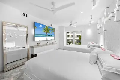 a white bedroom with two beds and a bath tub at Versace Mansion Neighbor (Floor 1,2,3) Sleeps 21 in Miami Beach