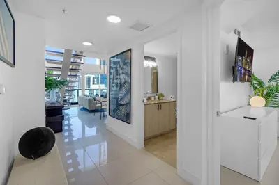 a living room with white walls and white tile floors at Brickell Residence 2BR Loft with amazing views in Miami
