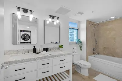 a bathroom with a sink and a toilet and a mirror at Brickell Residence 2BR Loft with amazing views in Miami
