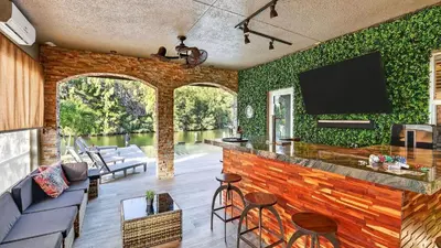 a living room with a bar and green walls at Riverside Veranda by AvantStay Waterfront Stay Infinity Pool Private Dock Easy Beach Access in Dania Beach