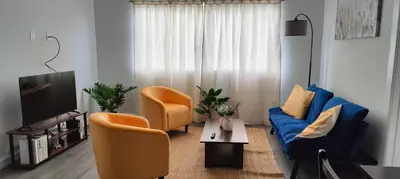a living room with a blue couch and orange chairs at Spacious 3BR-2BA Apt near Downtown-Miami Airport in Miami