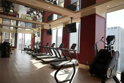 a gym with a row of treadmills and ellipticals at Stylish Minimalist 1BR in The Crosby in Miami