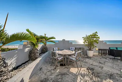 a patio with a table and chairs and the beach at Crown Jewel of Ocean Drive- 2 story Penthouse, 4 Bedrooms & Private rooftop spa in Miami Beach