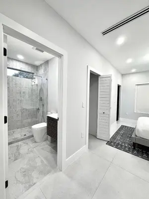 a white bathroom with a shower and a toilet at Art District Stay Wynwood & Design District Nearby in Miami