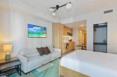 a bedroom with a white bed and a couch at Brand new Studio at The Crosby Miami Worldcenter in Miami