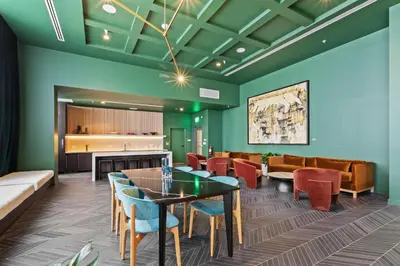a waiting room with green walls and a table and chairs at Brand new Studio at The Crosby Miami Worldcenter in Miami
