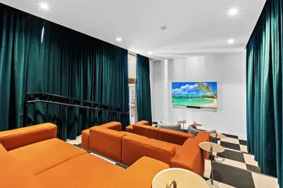 a living room with orange furniture and green curtains at Brand new Studio at The Crosby Miami Worldcenter in Miami