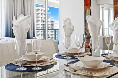 a dining table with wine glasses and plates on it at The W 1906 in Fort Lauderdale