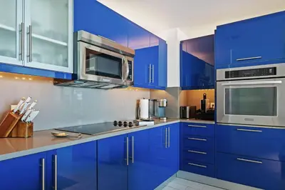 a kitchen with blue cabinets and stainless steel appliances at The W 1906 in Fort Lauderdale