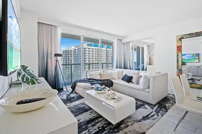 a living room with white furniture and a large window at The W 1906 in Fort Lauderdale