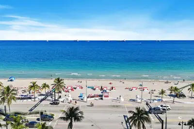 a beach with a lot of people and the ocean at The W 1906 in Fort Lauderdale