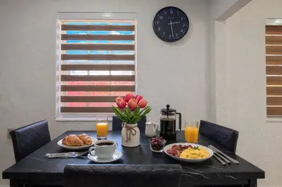 a dining room table with breakfast foods and a clock at Modern & Central Miami Free Parking & WiFi in Miami