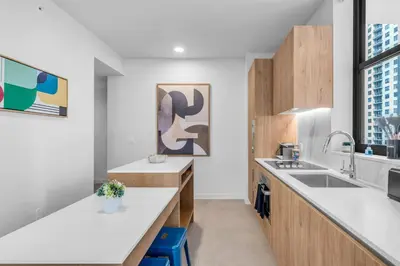 a kitchen with white countertops and wooden cabinets at 2BR Corner Suite MIA Wrap Balcony Rooftop Pool in Miami