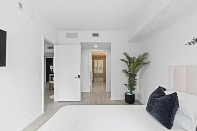 a bedroom with a white bed and a potted plant at The Downtown Miami 2BR 2BA Luxury Stay in Miami
