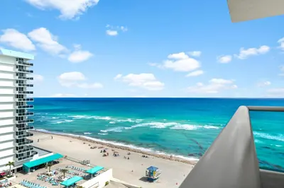 a view of the beach from the balcony of a resort at Oceanfront Condo with Direct Beach Access in Hollywood Beach