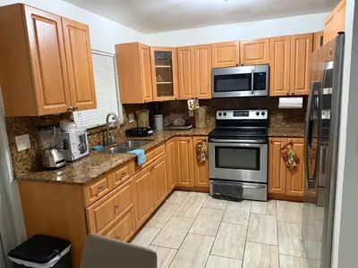 a kitchen with wooden cabinets and a stove top oven at Better Experience Property in Miramar