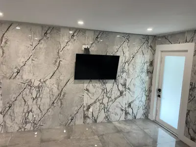 a living room with a tv on a marble wall at Waterfront ocean House Hollywood Hard Rock airport in Fort Lauderdale
