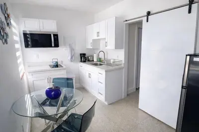 a kitchen with a glass table and a sink at Villa Clara ROYAL-Little Havana in Miami