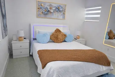 a bedroom with a bed with two blue pillows at Villa Clara ROYAL-Little Havana in Miami