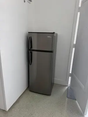 a stainless steel refrigerator in a corner of a room at Villa Clara ROYAL-Little Havana in Miami