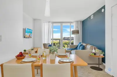 a dining room and living room with a table and chairs at Beachwalk Condo in Hallandale Beach
