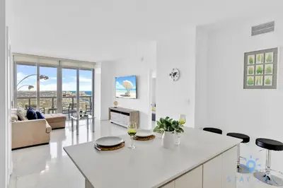 a kitchen and living room with a table and chairs at Beachwalk Condo in Hallandale Beach