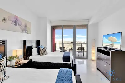 a bedroom with a bed and a view of the ocean at Beachwalk Condo in Hallandale Beach