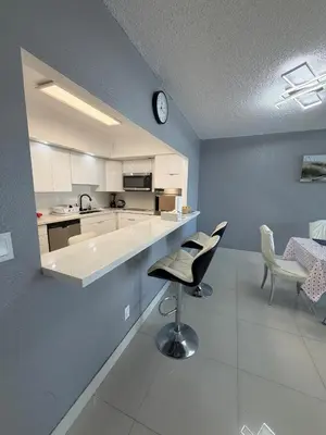 a kitchen with a table and chairs and a clock at Exceptional apartment in Sunny Isles in Sunny Isles Beach
