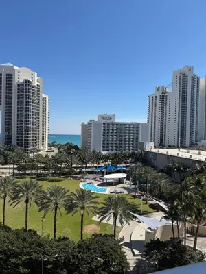 a view of a park with palm trees and buildings at Exceptional apartment in Sunny Isles in Sunny Isles Beach