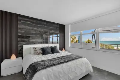 a bedroom with a bed and a large wall with windows at Huge Balcony Oceanfront 2 Bedrooms with Free Parking in Miami Beach