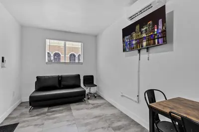 a living room with a black leather chair and a table at Cozy Studio 2 Blocks from the Beach - Unit #3 in Hollywood