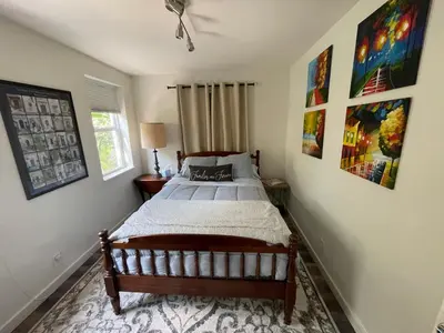 a bedroom with a bed and paintings on the walls at Spanish Style home in Miami Upper East Side in Miami