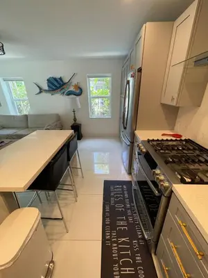a kitchen with a stove top oven next to a couch at Spanish Style home in Miami Upper East Side in Miami