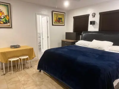 a bedroom with a blue bed and a table at My Help Comes from The Lord Miami in Palmetto Bay