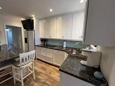 a kitchen with white cabinets and a counter top at Beachside One Bedroom Condo with Pool Access in Hollywood
