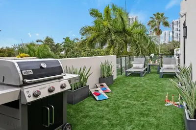 a backyard with a grill and green grass at Las Olas Villa in Fort Lauderdale