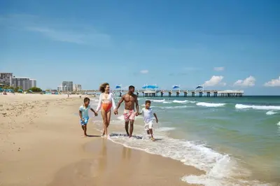 a family walking on the beach with the ocean at Las Olas Villa in Fort Lauderdale