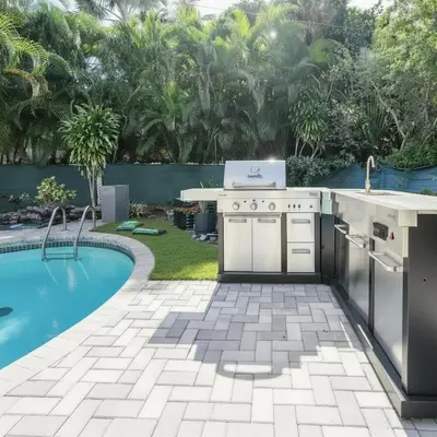 a backyard kitchen with a grill and a swimming pool at Tropical Retreat- Heated Pool 3 Miles to the Beach in Fort Lauderdale