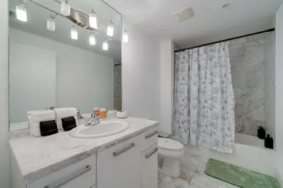 a bathroom with a sink and a toilet and a mirror at The Vizcayne Vibe- Sauna Pool and Sundeck in Miami