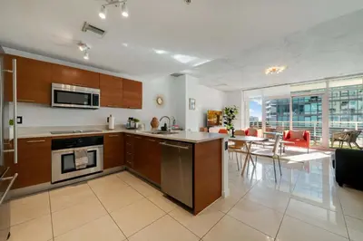 a kitchen and living room with a table and chairs at Midtown Rouge- Condo with City Views Pool & Gym in Miami